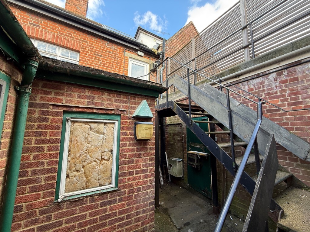 Lot: 37 - COMMERCIAL PROPERTY WITH SELF-CONTAINED SPLIT LEVEL FLAT ABOVE - Rear yard with metal staircase leading up to the flat